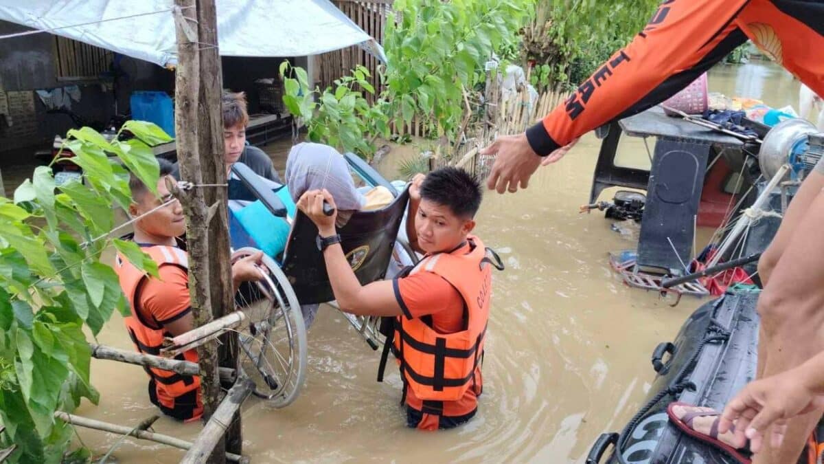 Philippine Coast Guard rescuers carefully evacuate a senior citizen in a wheelchair amid waist-deep floodwaters caused by Severe Tropical Storm Kristine in Zone 4, Libon, Albay, on October 23, 2024.