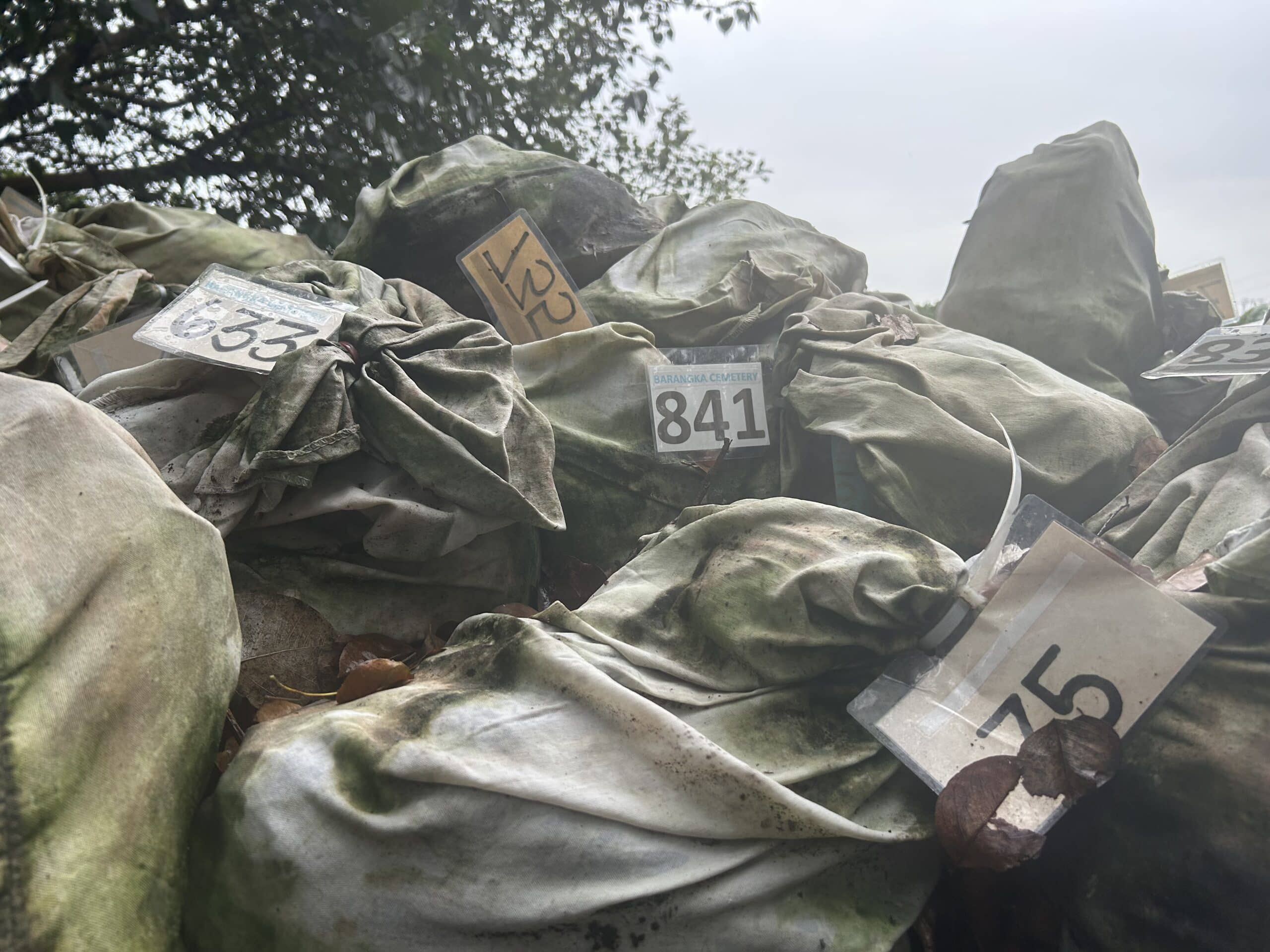 The sacks of human remains are tagged with numbers for identification purposes.