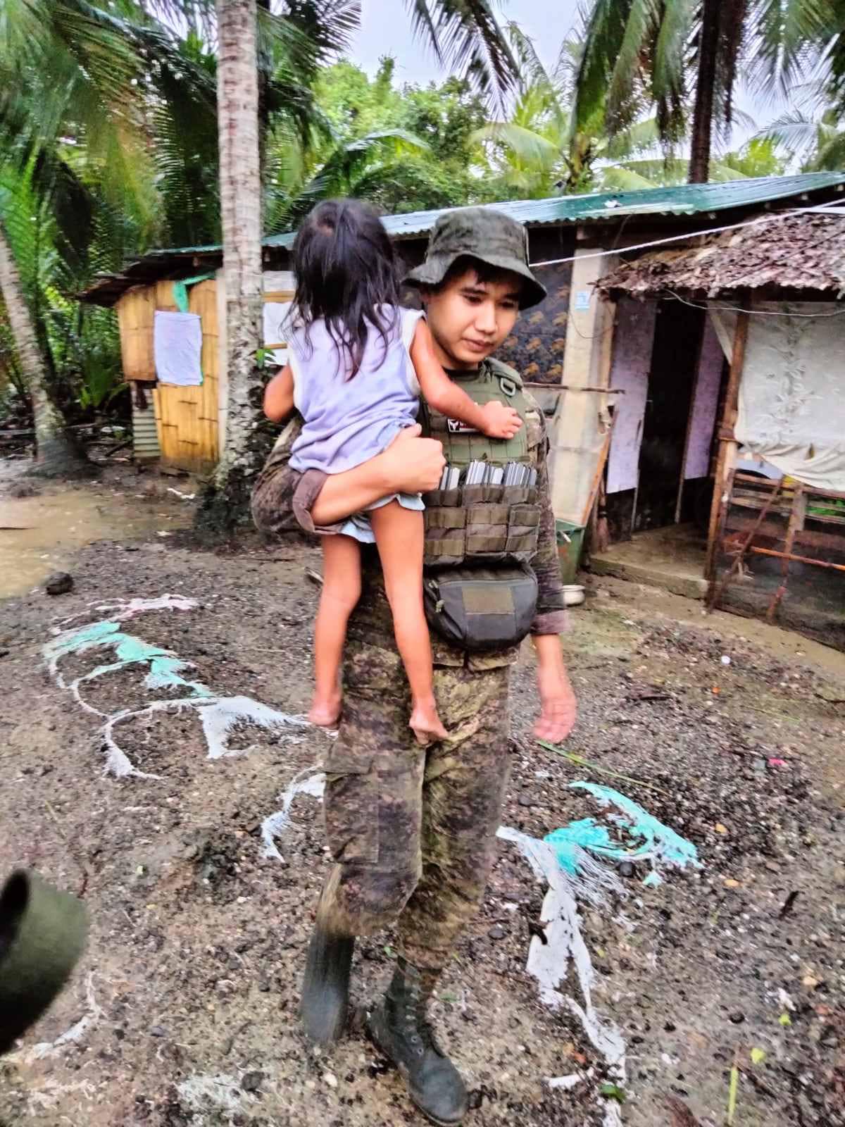 An 8th Infantry Division soldier carried a child during the rescue efforts amid the onslaught of tropical storm "Kristine" in Eastern Visayas on October 23, 2024.⁩