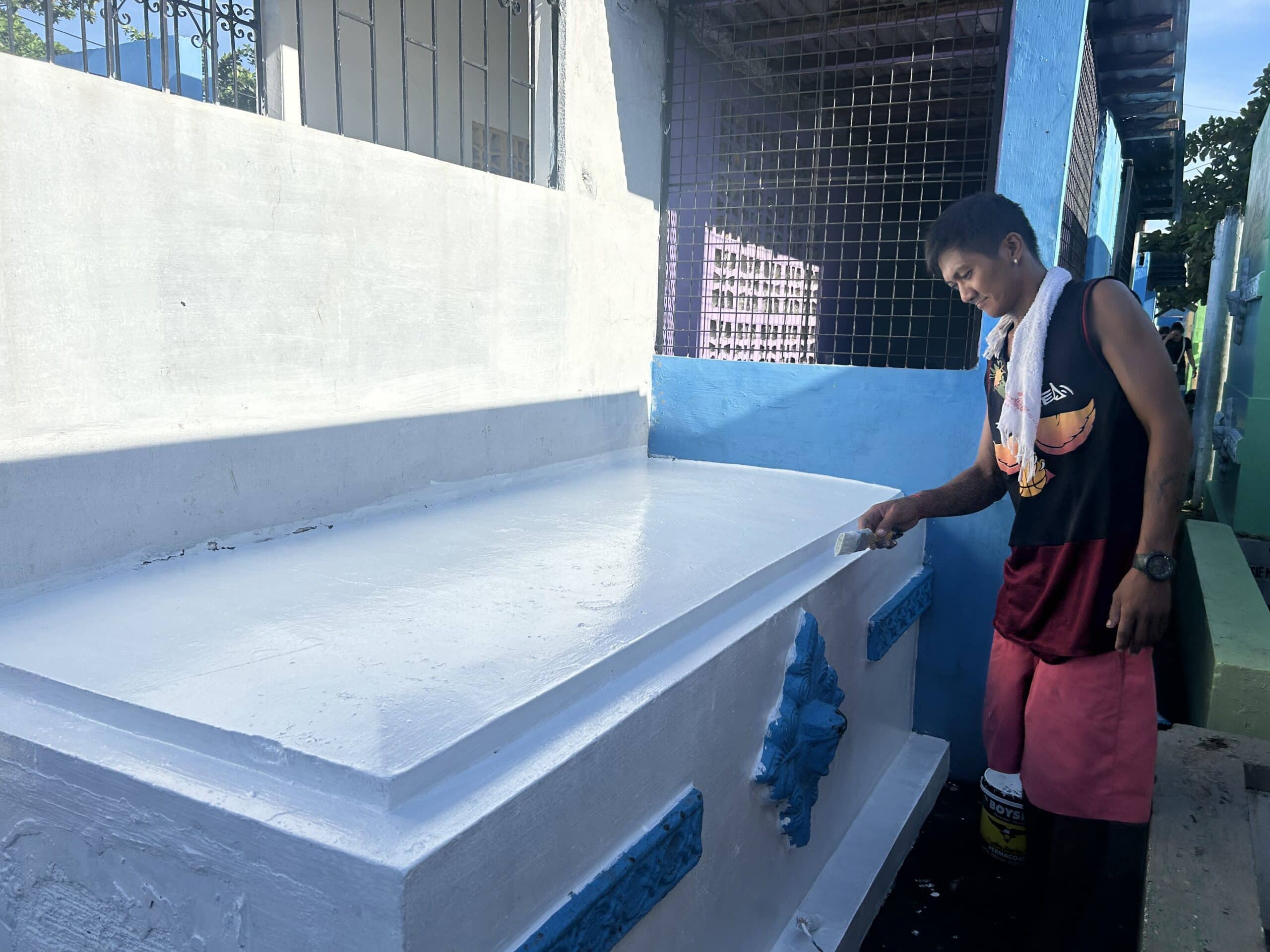 Aries Mariano, 37, has painted tombs inside the Manila North Cemetery for 10 years. (Photo by Dianne Sampang/INQUIRER.net)