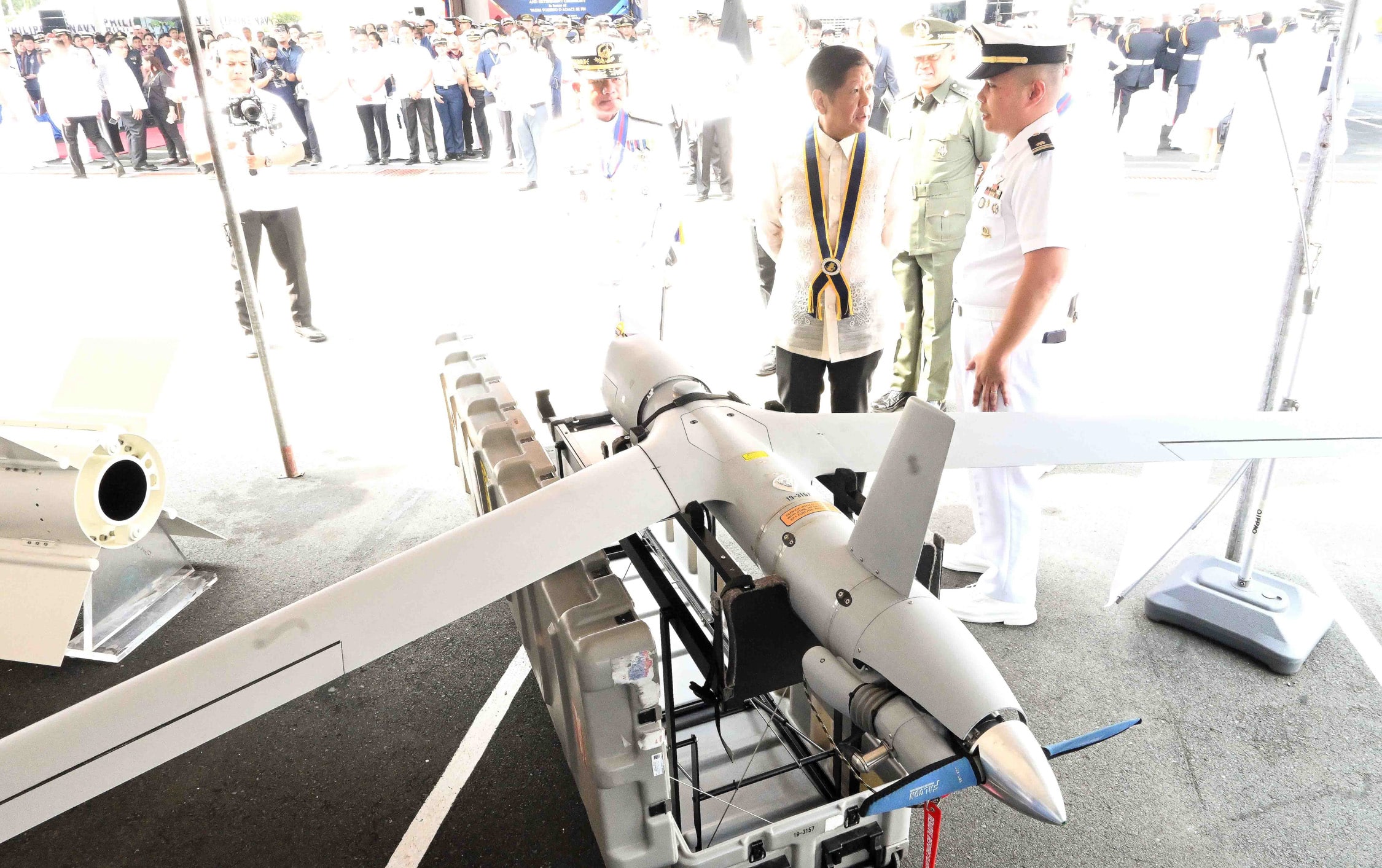 MODERNIZATION President Marcos speaks with a PhilippineNavy officer in front of a drone that would be used by the military. The Philippines is racing to modernize its Armed Forces amid belligerent moves by China in the West Philippine Sea. 