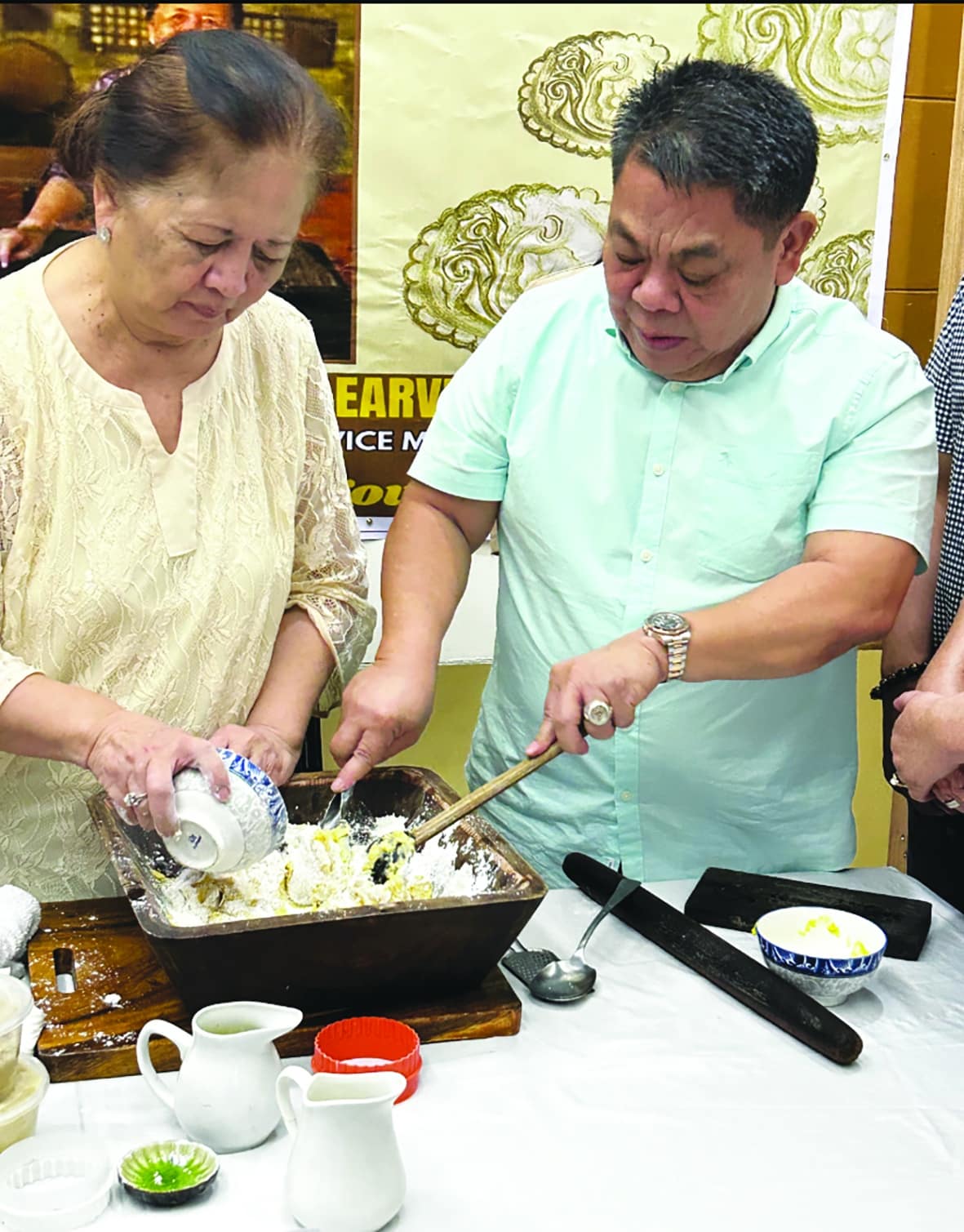 KEEPER OF CULINARY TRADITION Culinary heritage andchef Lillian Borromeo shows Bacolor Mayor Eduardo “Diman” Datu howthe pastry “Dulce Prenda” is made. She used grated and sweetened coconut filling instead of the traditional “kundol” (winter melon). 