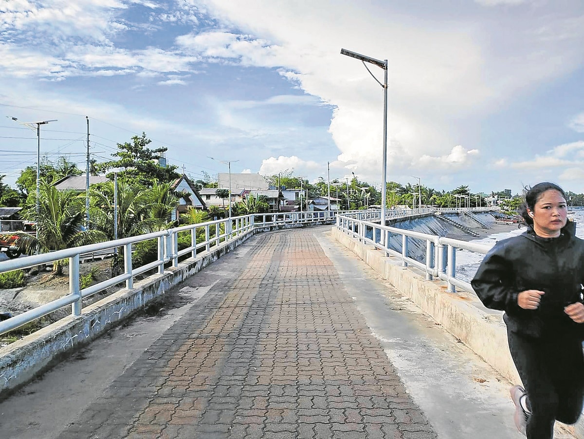 BRACING FOR CALAMITY The tide embankment project in Tacloban City, also called the “Great Wall of Leyte” and built to preventstormsurge, has become a favorite spot for joggers and fitness buffs.