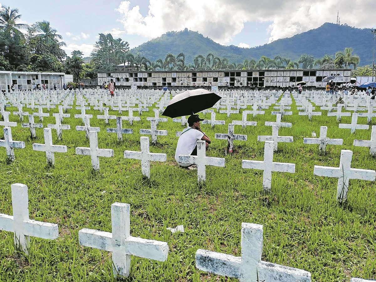 Romil Navidad,whose only daughter died whenTacloban was devastated by the strongest typhoon to hit inland, visits the mass burial site for Yolanda victims in Barangay Basper.