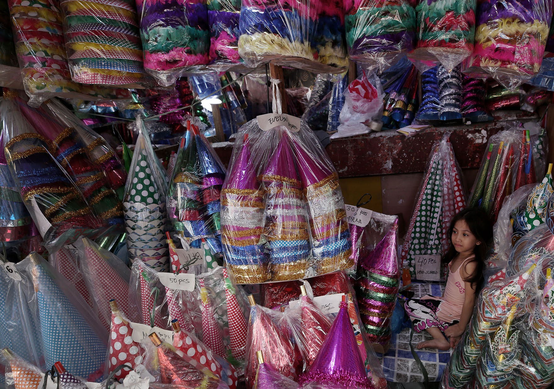 KEEP KIDS SAFE Six-year old Princess Tagureta helps watchover her family stall in Divisoria, Manila, selling traditional horns for New Year’s Eve. 