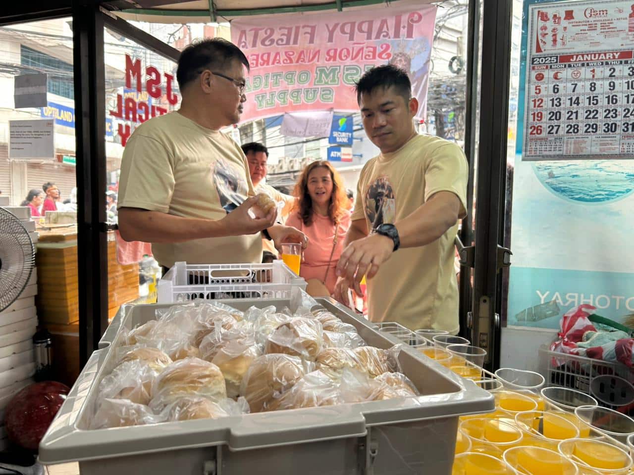 Staff of an eyewear store give out sandwiches and cups of juice to Nazareno devotees in the vicinity of Quiapo Church on Thursday afternoon, Jan. 9, 2025.