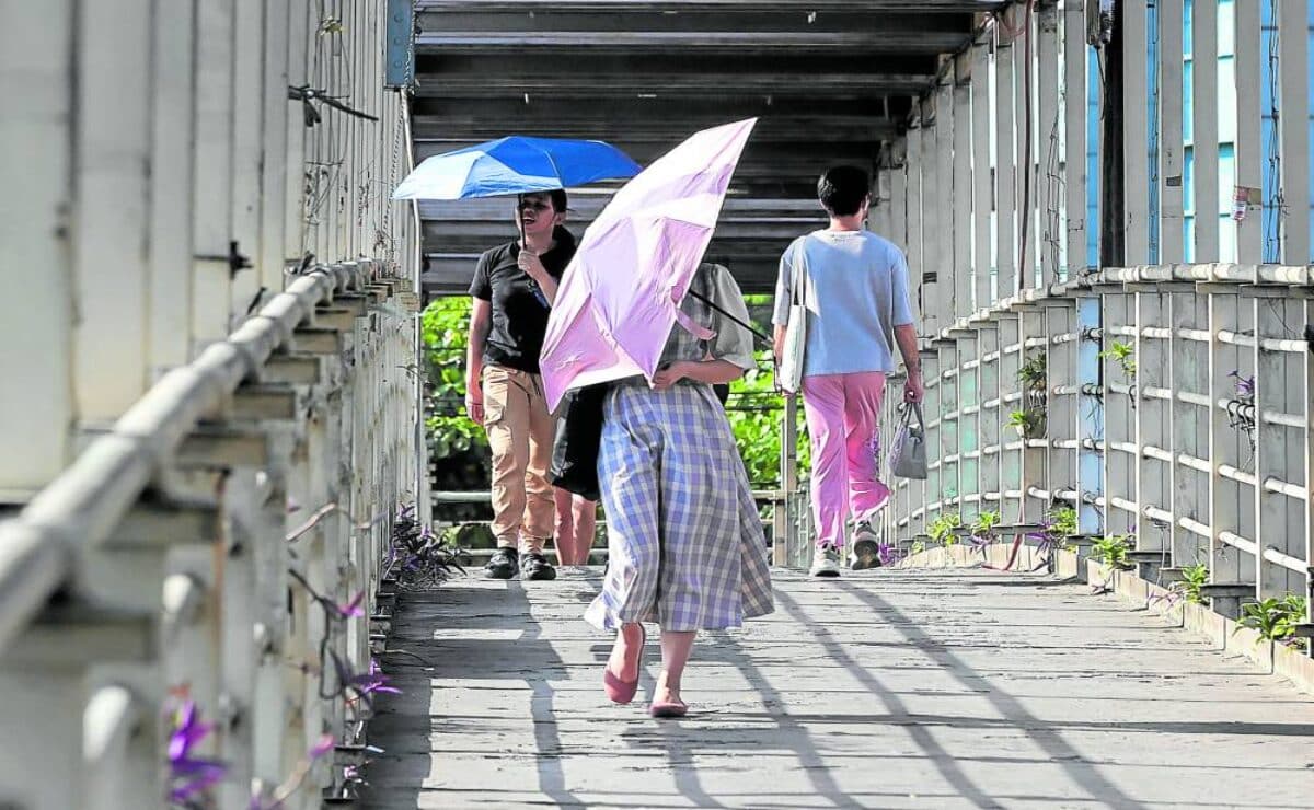 Pedestrians in Quezon City use umbrellas to shield themselves from the sun amid the rising heat index beginning March. On Tuesday, state weather experts said 14 areas are forecast to reach danger-level heat indices. — Photo by Grig C. Montegrande 
