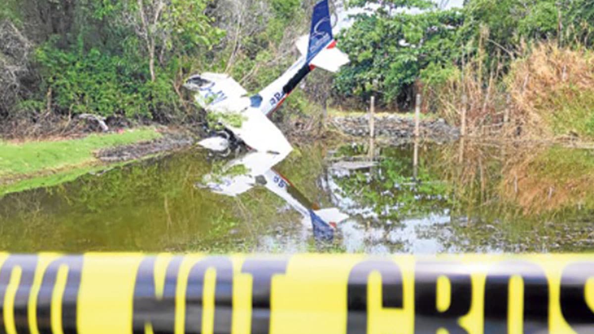 NOSE DOWN The Cessna 152 aircraft lies partially in water with its nose and cockpit crumpled after it crashed in a vacant lot just outside Lingayen Airport in Lingayen, Pangasinan, where it took off Sunday morning, March 30, killing two persons on board. —WILLIE LOMIBAO
