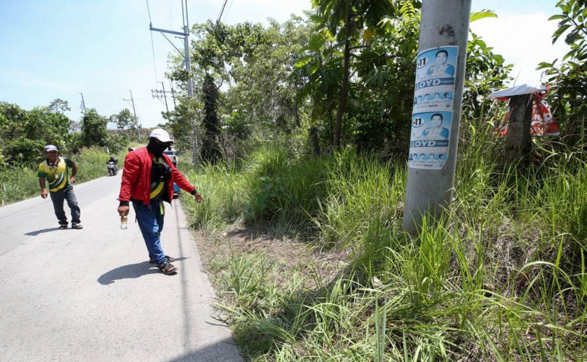 A barangay official points the spot where the bodies of businessman Anson Que and his driver was found.