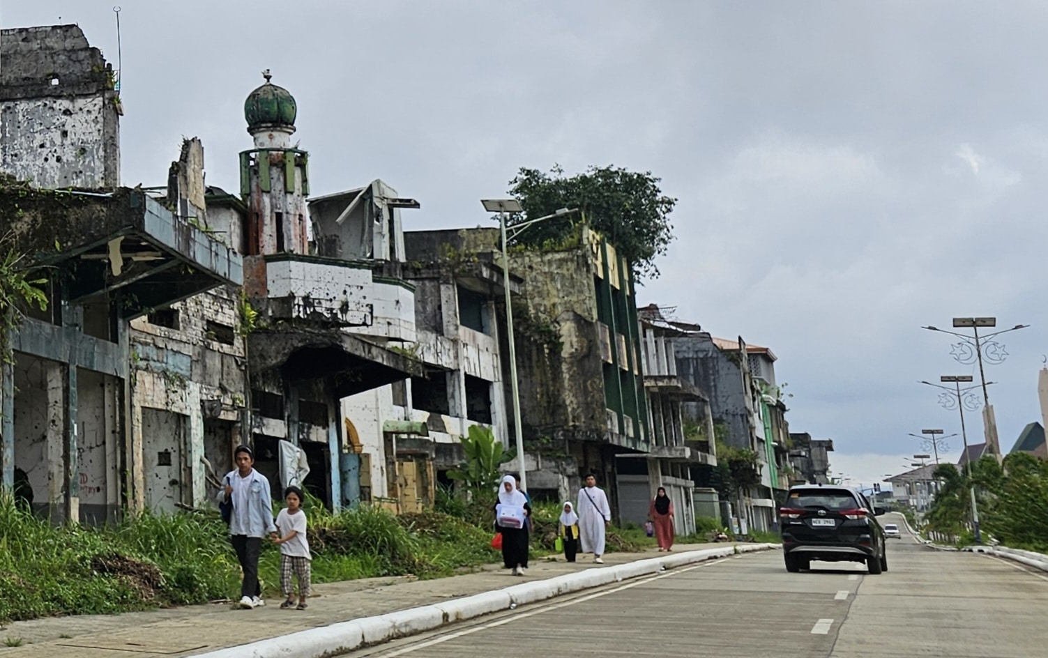 HOPEFUL Residents of Marawi City walk home amid buildings ruined by the 2017 siege in this photo taken in October 2024. The city pins its hope on compensation for damaged properties for itsfull recovery from the five-month conflict eight years ago.