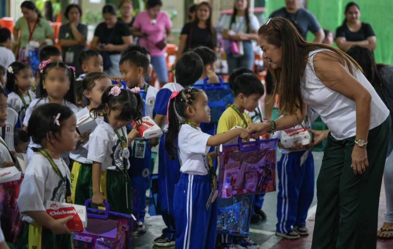 [Teachers, staff and kindergarten pupils of Andres Bonifacio Elementary School with the school supply kits and Jollibee food packs donated by Jonathan Michael Sterling in Tayuman, Manila, on September 2, 2026. Photo courtesy of Jonathan Sterling.]