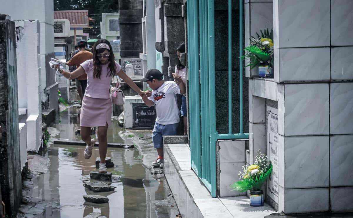 HONORING THE DEPARTED: Despite some areas being flooded following this morning’s downpour, early cemetery-goers, along with hired cleaners and painters, braved the floodwaters to prepare gravesites at Tanza Public Cemetery in Iloilo City on Oct. 31, 2026.