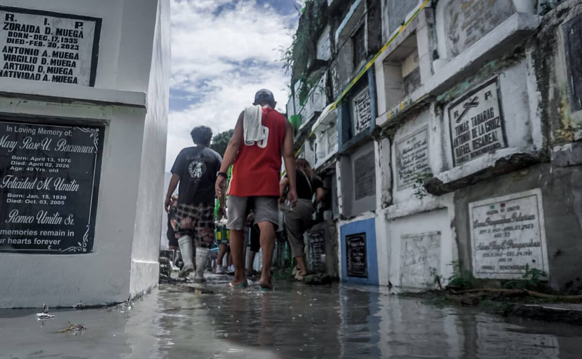 HONORING THE DEPARTED: Despite some areas being flooded following this morning’s downpour, early cemetery-goers, along with hired cleaners and painters, braved the floodwaters to prepare gravesites at Tanza Public Cemetery in Iloilo City on Oct. 31, 2026.